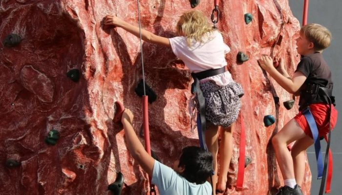 Children rock climbing a mobile wall while on school camp at StayKCC