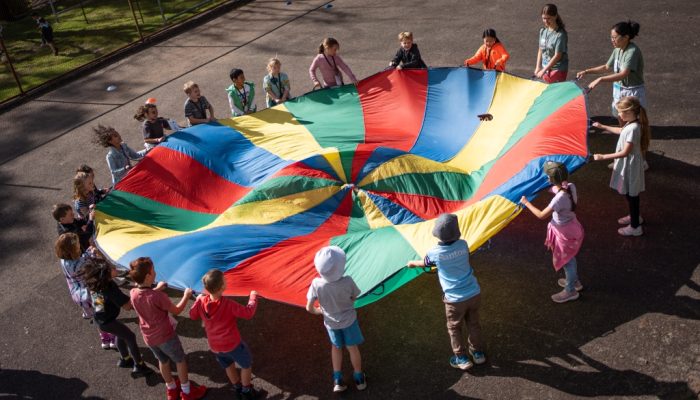 School children undertaking a team-building activity on the basketball court